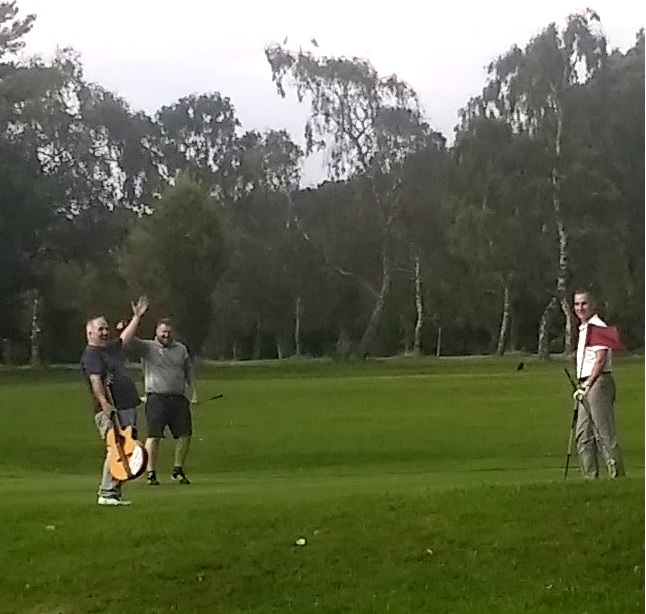 The minstrel sinks a putt using his guitar as a putter