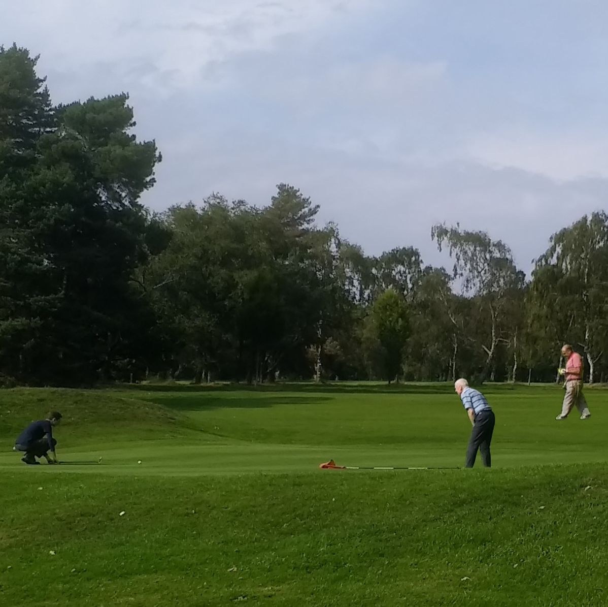 Robin, Andy and Pete B sizing up their putts