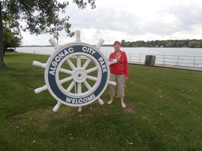 Anne, standing at the city park sign, Algonac