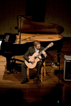 Chris in a concert hall playing guitar