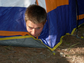 Chris emerging headfirst from a tent