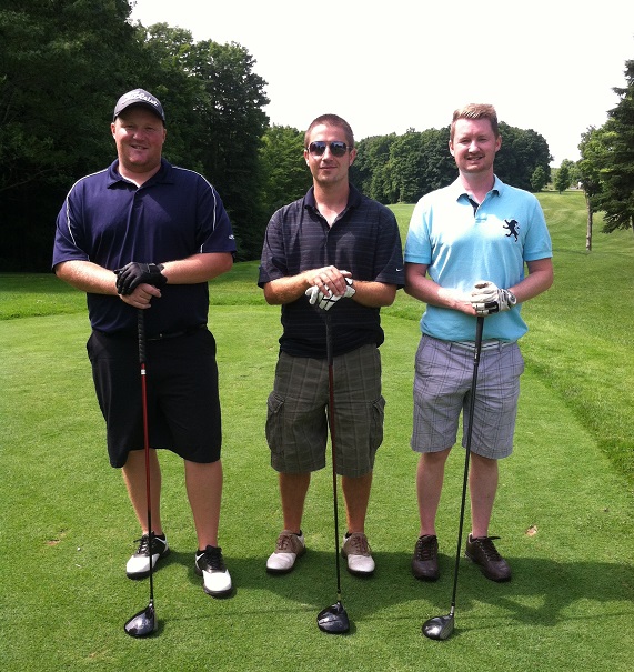 Jamie, Chris and Dean posing in golf attire with drivers afore