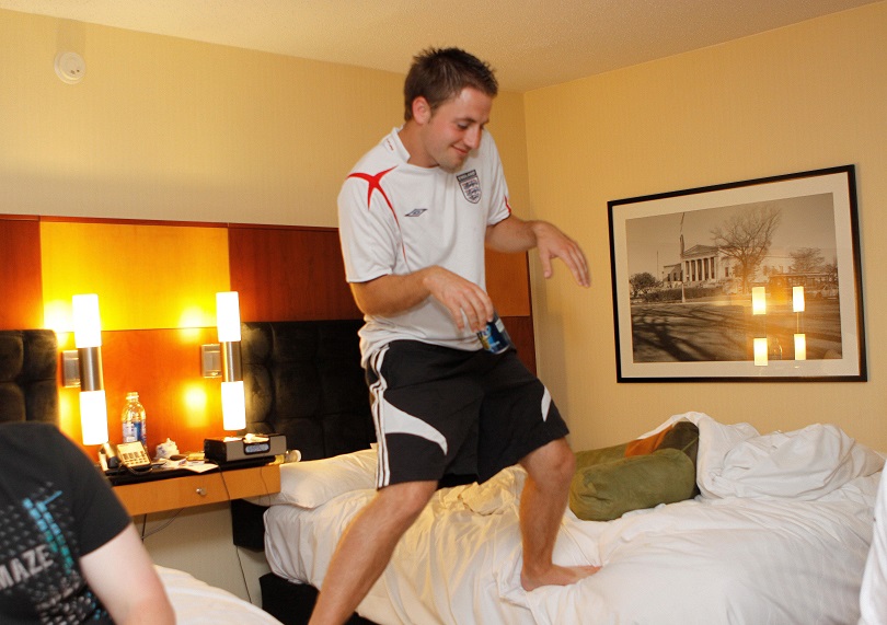 Chris, larking around straddling two beds